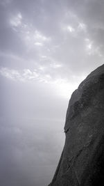 Rock formation by sea against sky
