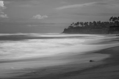 Long exposure photo of the beach, the beach with coconut trees on the edge of a steep cliff