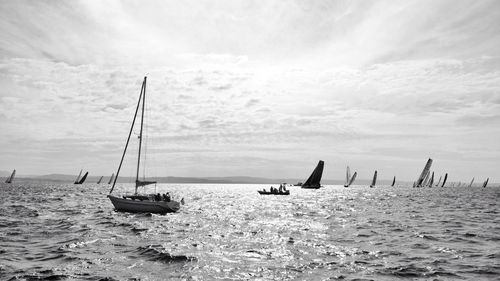 Boats sailing in calm sea against sky