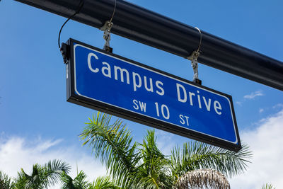 Low angle view of road sign against blue sky