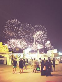 People watching firework display at night