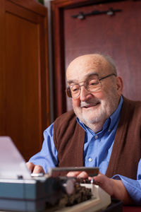Senior man using typewriter