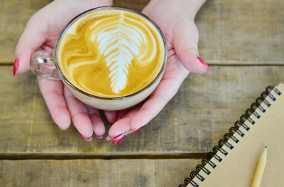 Close-up of hand holding coffee cup