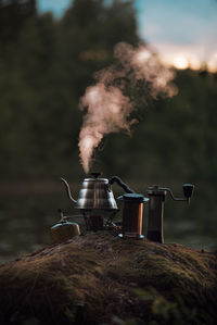 Boiling kettle and coffee or tea accessories in the evening or morning in the woods