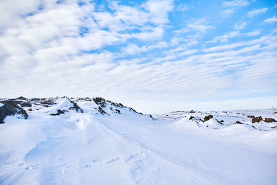 Snow covered landscape against sky