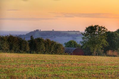 Scenic view of field against sky at sunset