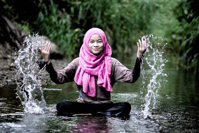 View of happy girl splashing water