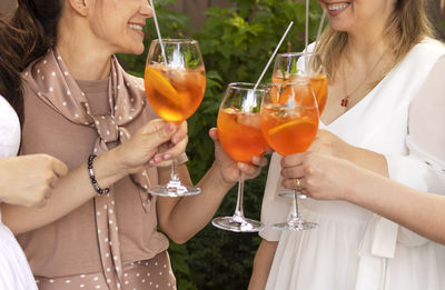 Midsection of woman holding wineglass