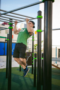 Muscular man exercising against sky at park