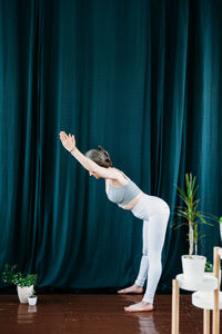 Young woman dancing on table at home