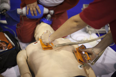 High angle view of doctors practicing with cpr dummy at hospital