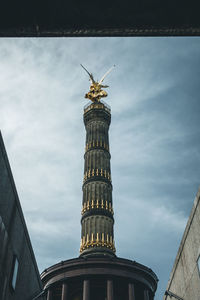 Low angle view of statue of building against cloudy sky