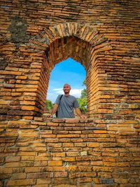 The man standing on the old brick wall