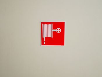 Close-up of red telephone over white background