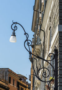 Low angle view of street light against buildings