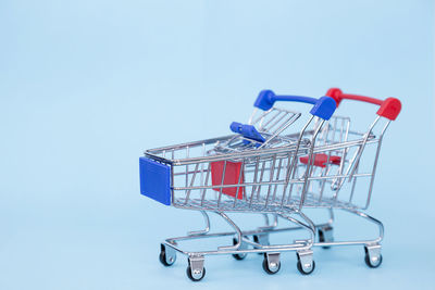 Close-up of shopping cart against blue background