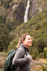 Young woman looking at waterfall on mountain