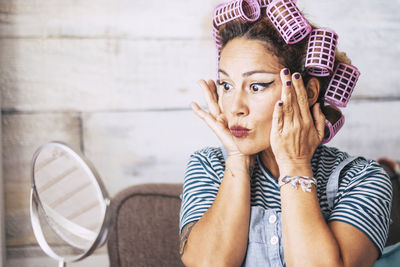 Woman wearing hair curlers at home