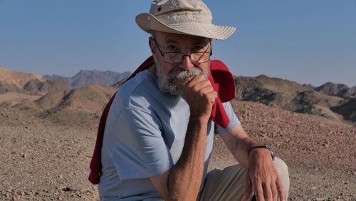 Senior man sitting on mountain at desert 