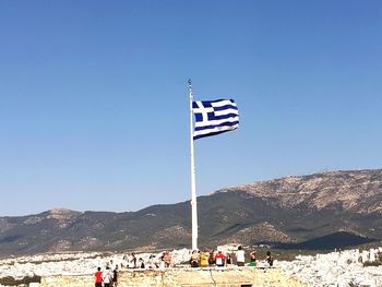 People on mountain road against clear blue sky