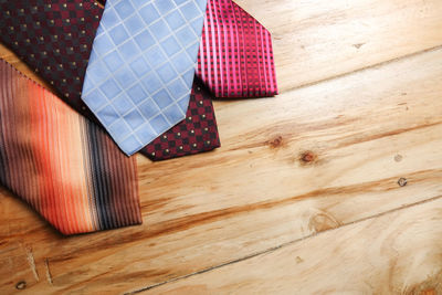 High angle view of colorful neckties on hardwood floor