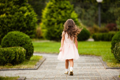 Rear view of woman walking on footpath