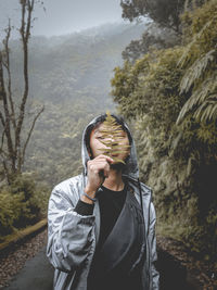 Portrait of young man standing in forest