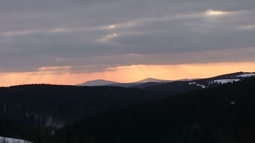 Scenic view of silhouette mountains against sky at sunset