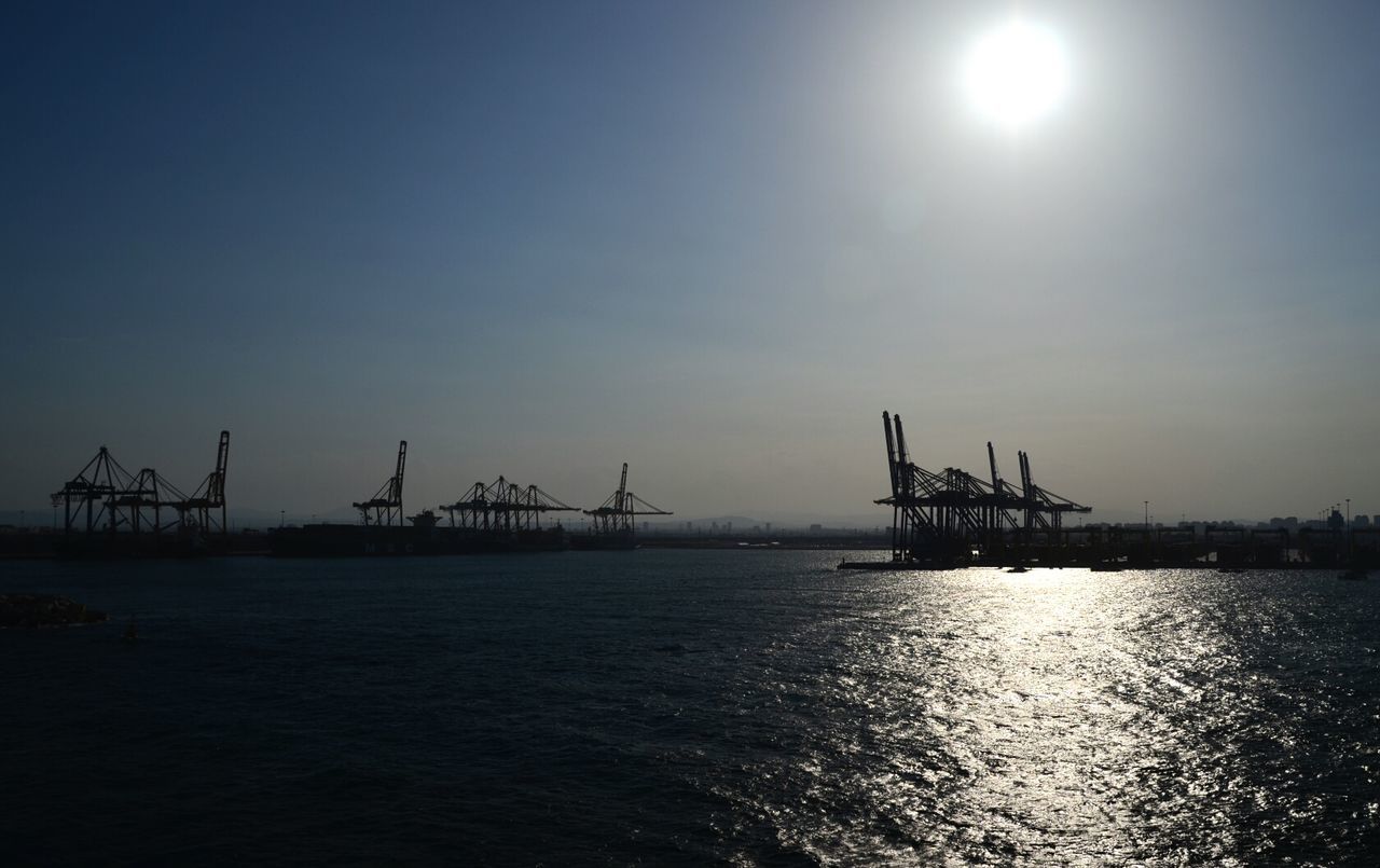 water, waterfront, crane - construction machinery, sea, silhouette, commercial dock, sun, crane, built structure, sky, sunset, clear sky, harbor, architecture, industry, nature, nautical vessel, copy space, tranquility, outdoors