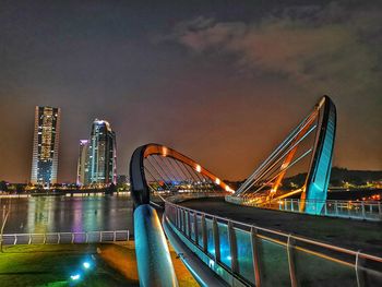 Illuminated bridge against sky at night