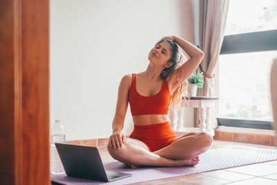 Young woman using laptop while sitting at home