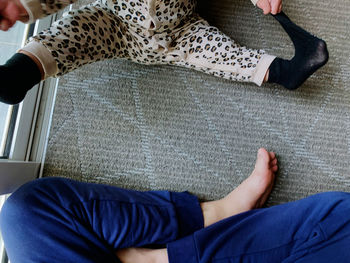 Low section of man and woman sitting on floor