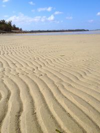 View of calm beach against blue sky