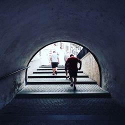 Rear view of people walking on staircase