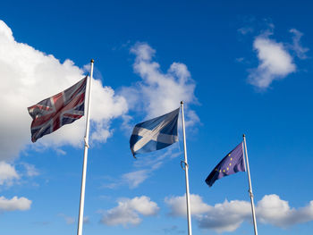 Low angle view of flag flags against blue sky