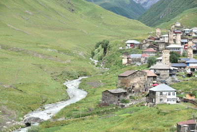 Scenic view of landscape and houses by mountain