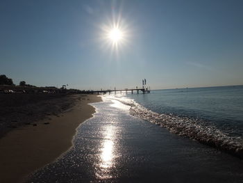 Scenic view of sea against bright sun