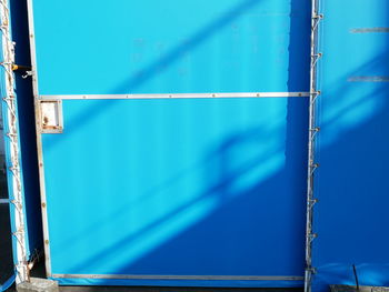 Full frame shot of metal fence against blue sky