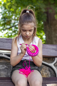 Portrait of young woman sitting on bench