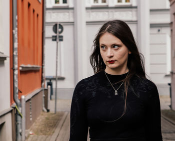 Portrait of young woman standing in city