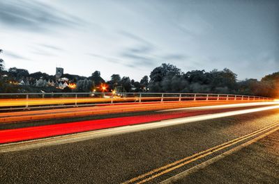 Light trails on road against sky in city