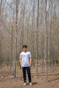 Portrait of young man standing in forest