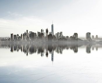 Panoramic view of lake and cityscape against sky