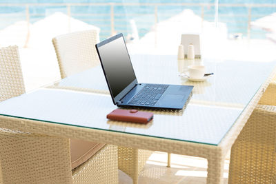 Workplace in a cafe with a sea view. man working on a laptop in a cafe. copy space, mock up.