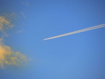 Low angle view of vapor trail against blue sky