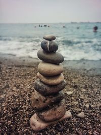 Stack of pebbles on beach against sky