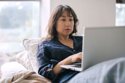 Young woman using laptop at home