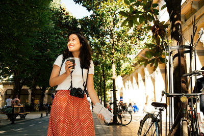 Woman standing on bicycle in city