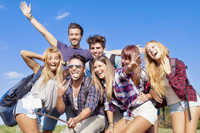 Group of friends taking a self portrait with selfie stick outdoor