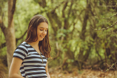 Young woman standing in forest